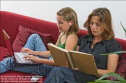 Viennaslide-64710359 Mutter liest Buch, Tochter benutzt Laptop - Mother reading book, daughter using laptop