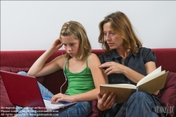 Viennaslide-64710361 Mutter liest Buch, Tochter benutzt Laptop - Mother reading book, daughter using laptop