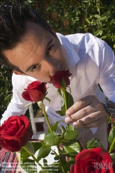 Viennaslide-72000157 Junger Mann riecht an Rosen - Young man smelling at red rose