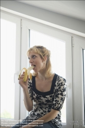 Viennaslide-72000292 Junge Frau isst eine Banane - Young Woman eating a Banana