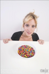 Viennaslide-72000307 Junge Frau vor einer Schale mit Schokolinsen - Young woman in front of bowl with chocolate lentils