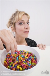 Viennaslide-72000308 Junge Frau vor einer Schale mit Schokolinsen - Young woman in front of bowl with chocolate lentils