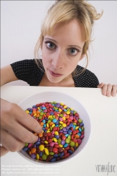 Viennaslide-72000309 Junge Frau vor einer Schale mit Schokolinsen - Young woman in front of bowl with chocolate lentils