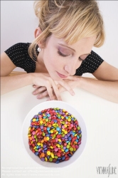 Viennaslide-72000311 Junge Frau vor einer Schale mit Schokolinsen - Young woman in front of bowl with chocolate lentils