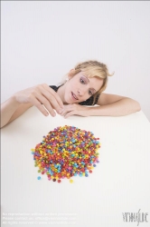 Viennaslide-72000313 Junge Frau vor einer Schale mit Schokolinsen - Young woman in front of bowl with chocolate lentils