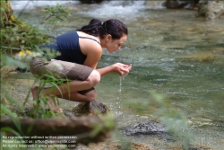 Viennaslide-72000633 Junge Frau trinkt Wasser aus einem Bach - Young Woman drinking Water out of a River