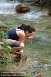 Viennaslide-72000635 Junge Frau trinkt Wasser aus einem Bach - Young Woman drinking Water out of a River