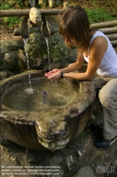 Viennaslide-72000637 Junge Frau trinkt Wasser aus einem Brunnen - Young Woman drinking Water out of a Fountain