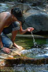 Viennaslide-72000638 Junge Frau trinkt Wasser aus einem Bach - Young Woman drinking Water out of a River